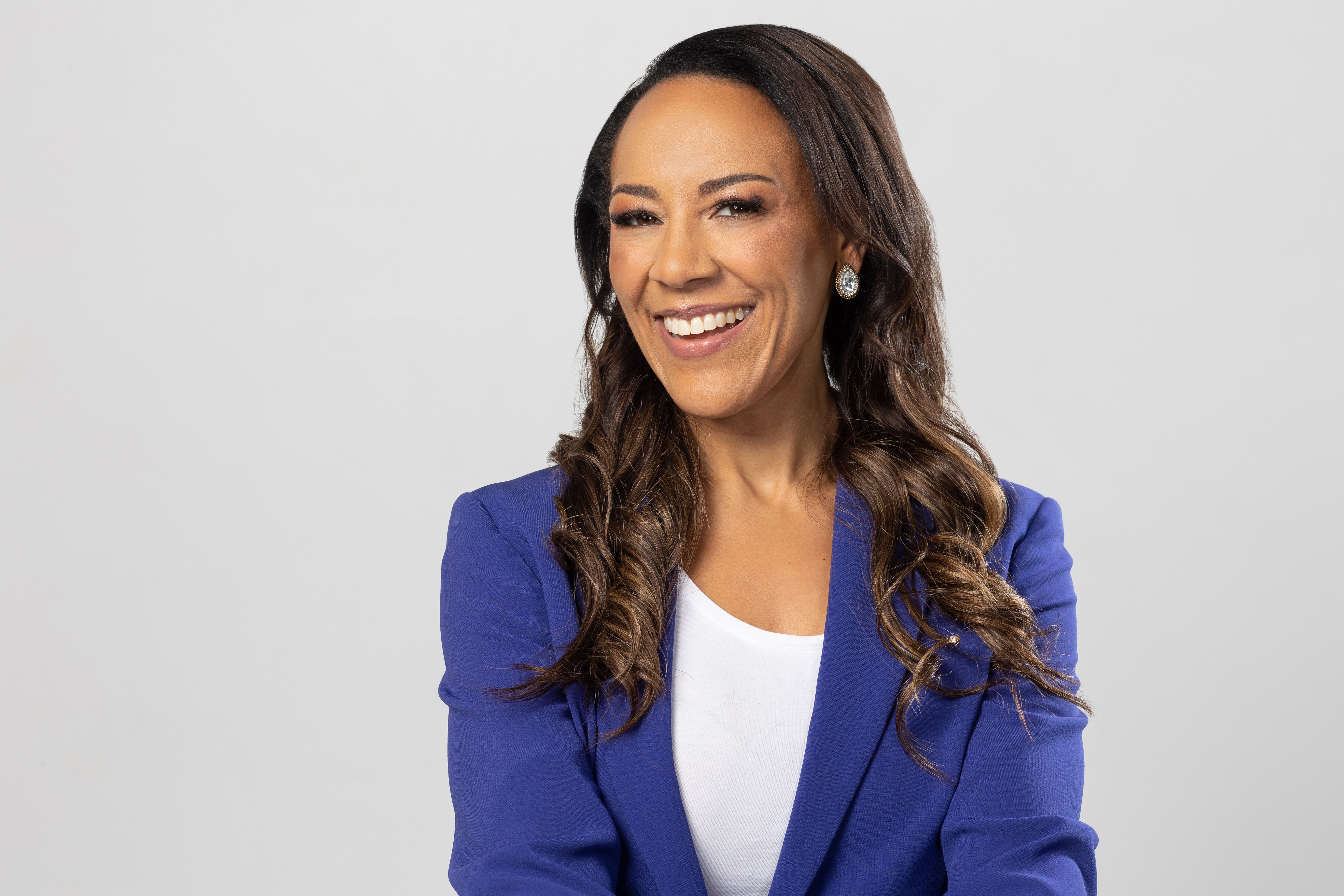 Rhea blue suit half shot smiling